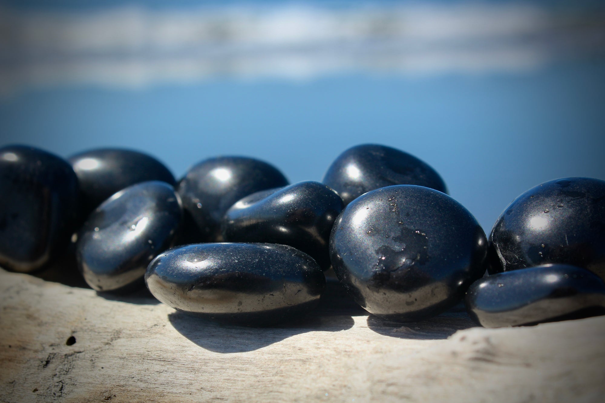 "Shungite tumble stone: A polished black stone with unique patterns and textures, emitting an aura of mystery and intrigue. Its surface gleams with an enigmatic luster, hinting at the ancient origins and extraordinary properties concealed within."