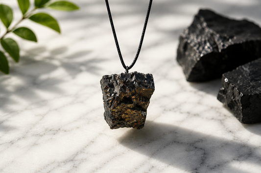 elite raw shungite pendant hanging on marble background 