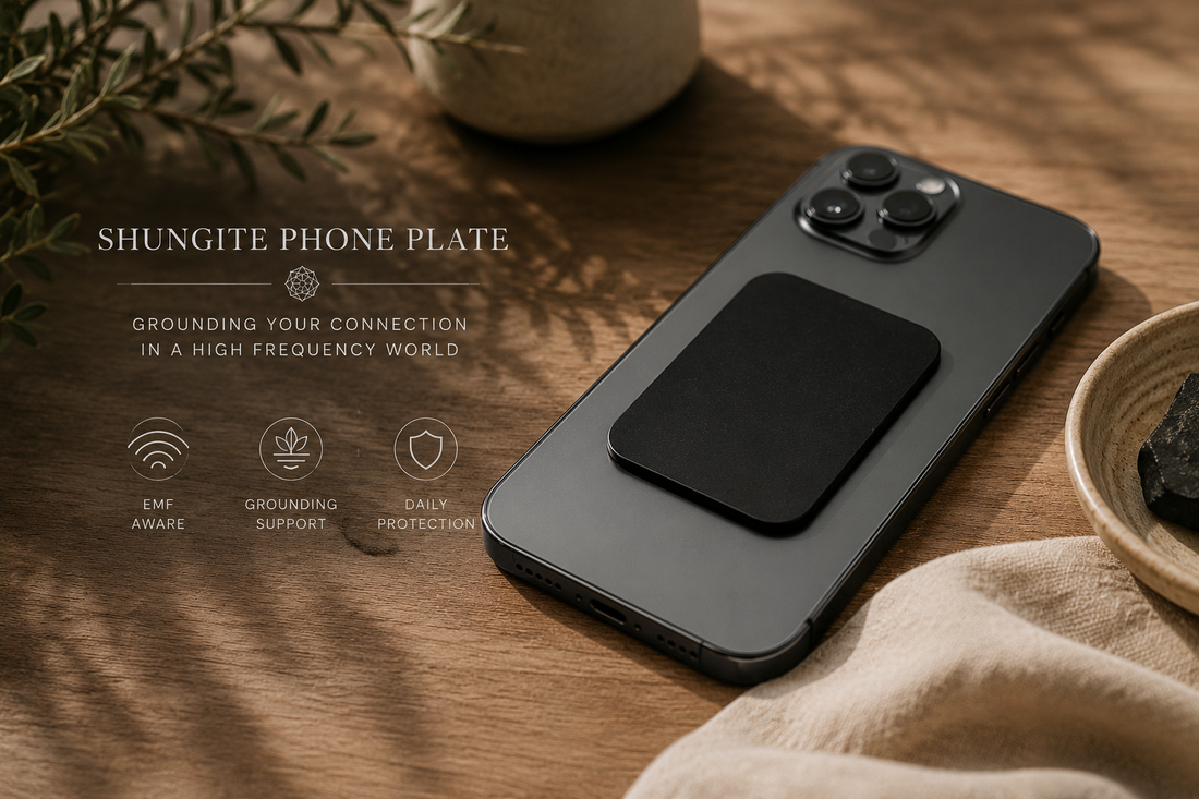 shungite phone plate attached to smartphone on wooden table with natural sunlight minimal grounding lifestyle setting