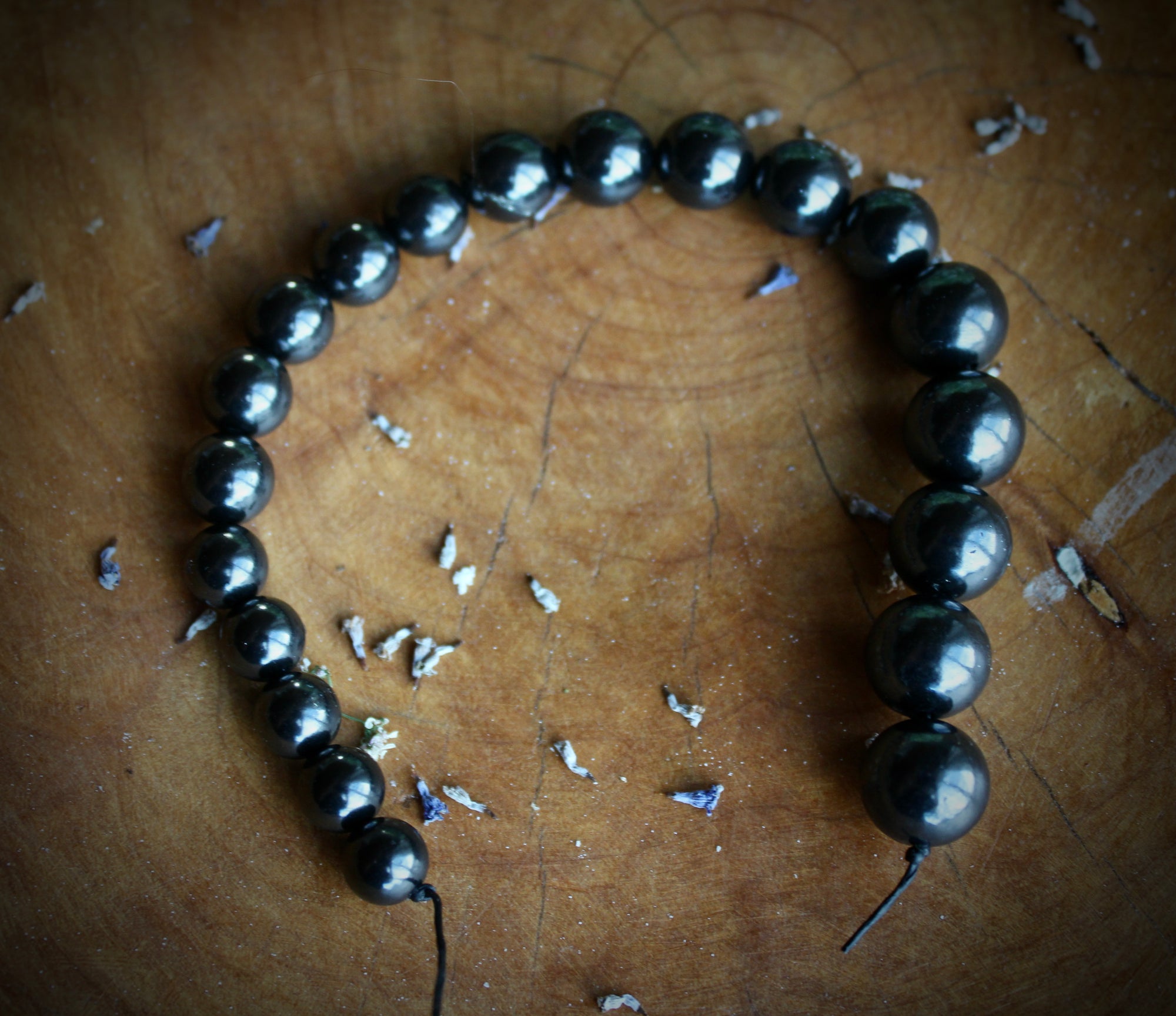 "An image showcasing a string of Shungite beads, ranging from 6mm to 12mm in size, each meticulously crafted and gleaming with a natural luster. These beads emanate an aura of spiritual energy and earthly beauty, perfect for creating unique and transformative jewelry pieces."