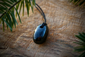 Tumble Shungite stone pendant with a smooth, polished finish, featuring a hole and adjustable string for a stylish and protective necklace.