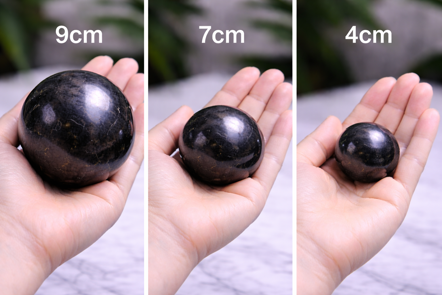 “Shungite spheres in 9cm, 7cm, and 4cm sizes shown in hand for scale”