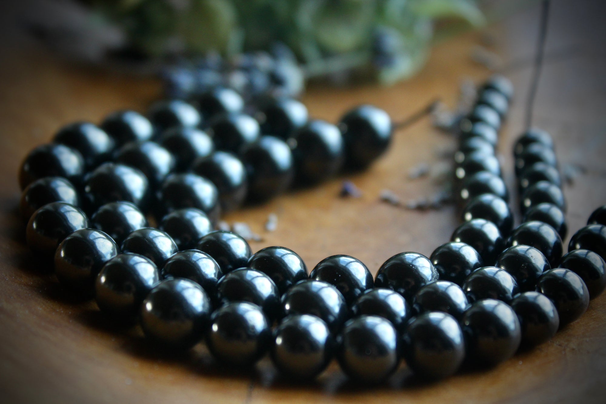 "An image showcasing a string of Shungite beads, ranging from 6mm to 12mm in size, each meticulously crafted and gleaming with a natural luster. These beads emanate an aura of spiritual energy and earthly beauty, perfect for creating unique and transformative jewelry pieces."