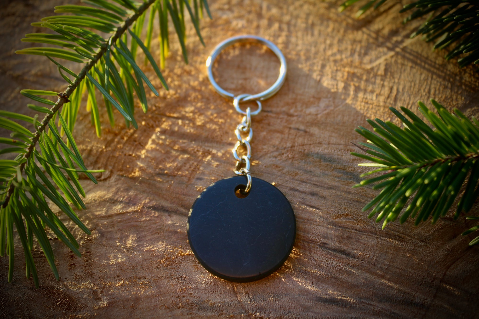 Round Shungite keychain with a smooth, polished design for EMF protection and energy cleansing.