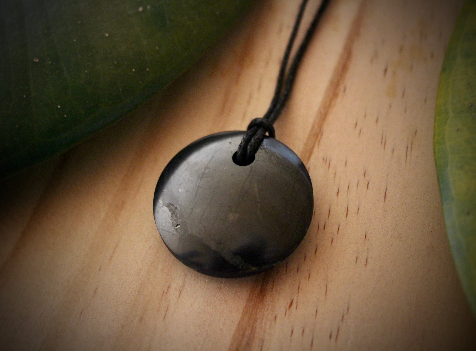 Shungite Sacred Circle Pendant - "Isis" (3cm), displaying unique markings and veins, crafted from genuine shungite stone.