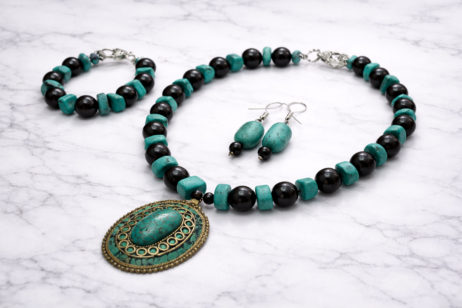 Handmade shungite and turquoise jewelry set with necklace, bracelet and earrings on marble background