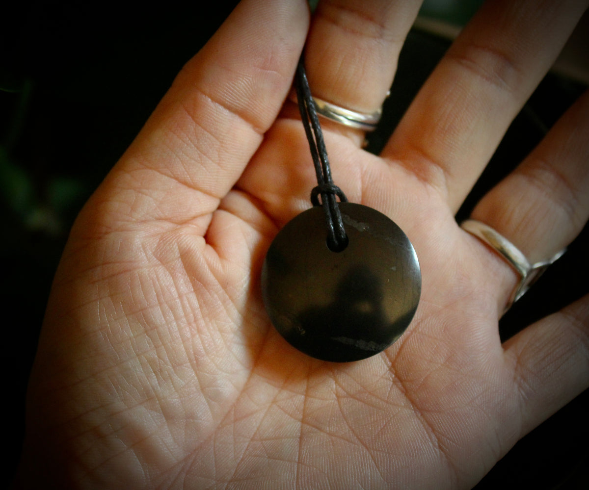 Shungite Sacred Circle Pendant - "Isis" (3cm), displaying unique markings and veins, crafted from genuine shungite stone.